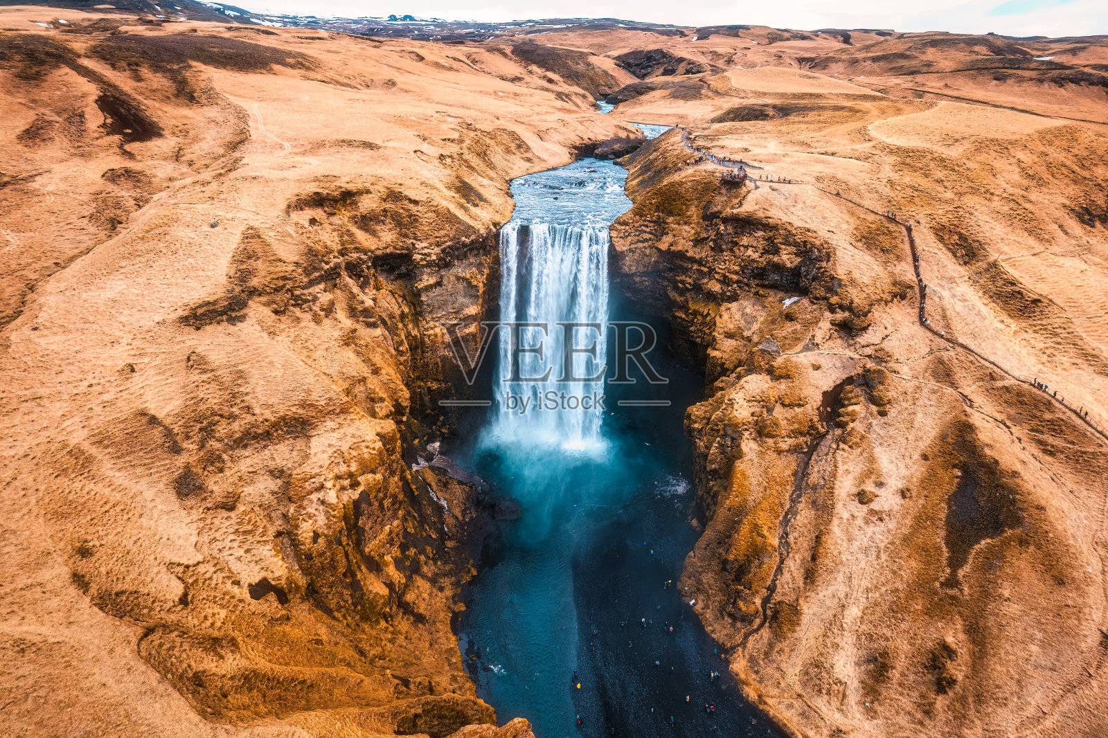 强大的斯科加弗斯瀑布在冰岛的秋天与干燥的山脉一起流动照片摄影图片