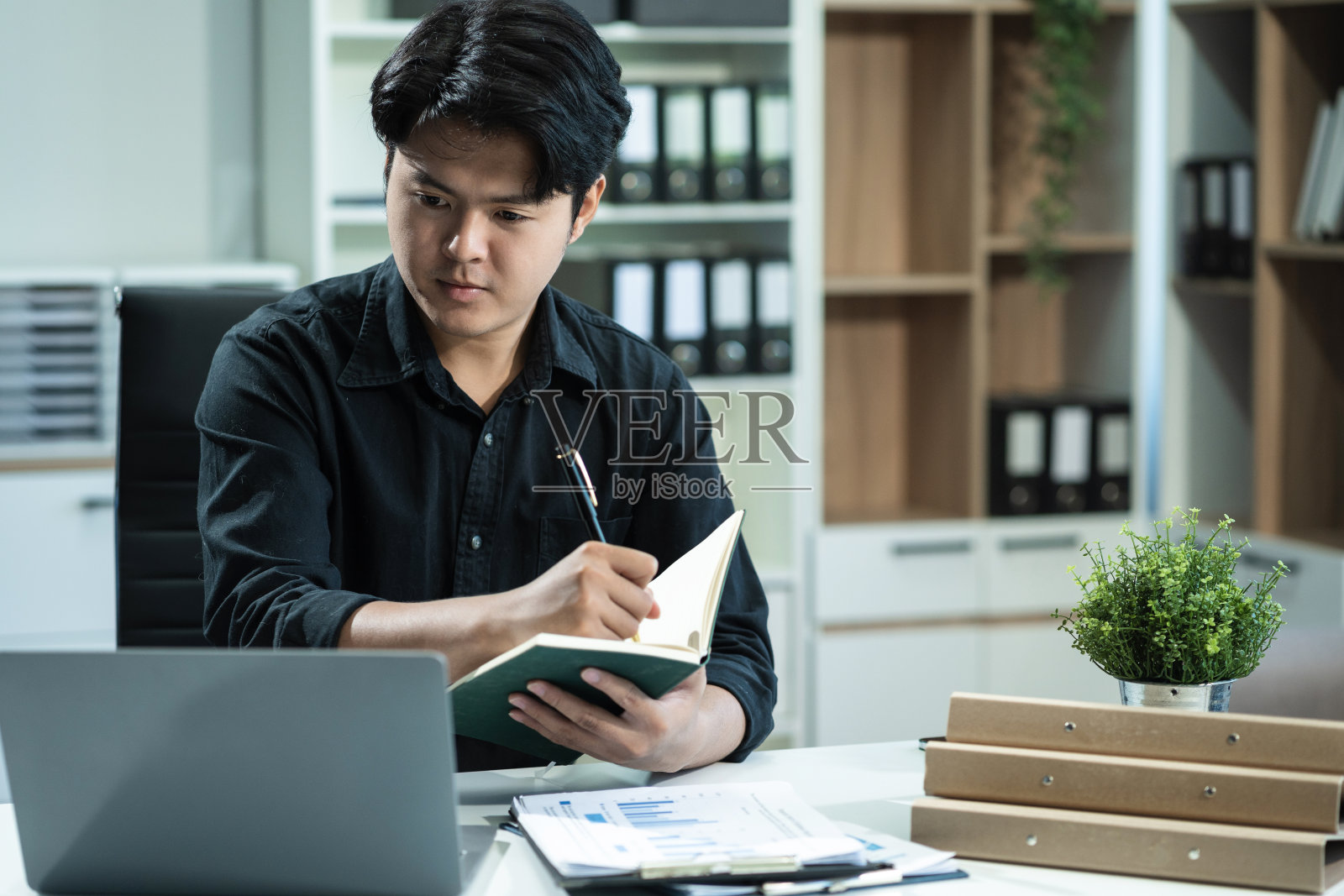 年轻员工使用电脑在线工作，做搜索，做笔记，在办公室观看商业培训网络研讨会，在工作时看着笔记本电脑进行虚拟聊天会议。照片摄影图片