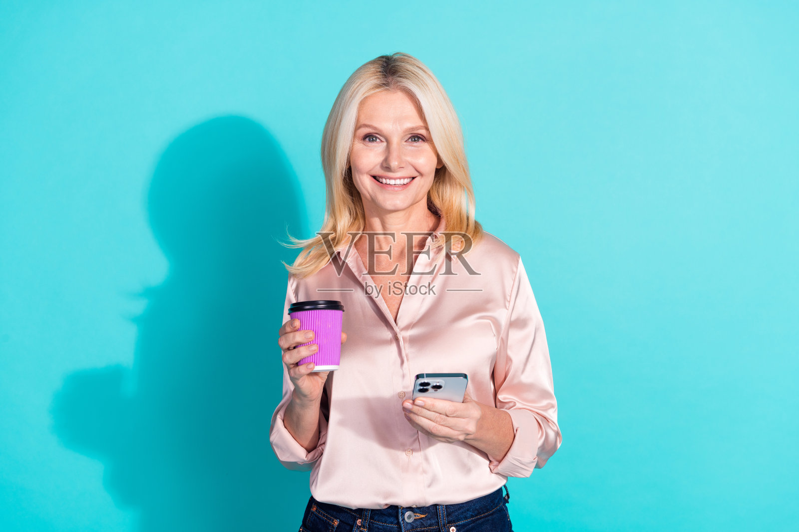 漂亮优雅的女士的照片拿着手机咖啡穿着衬衫孤立的蓝绿色背景照片摄影图片