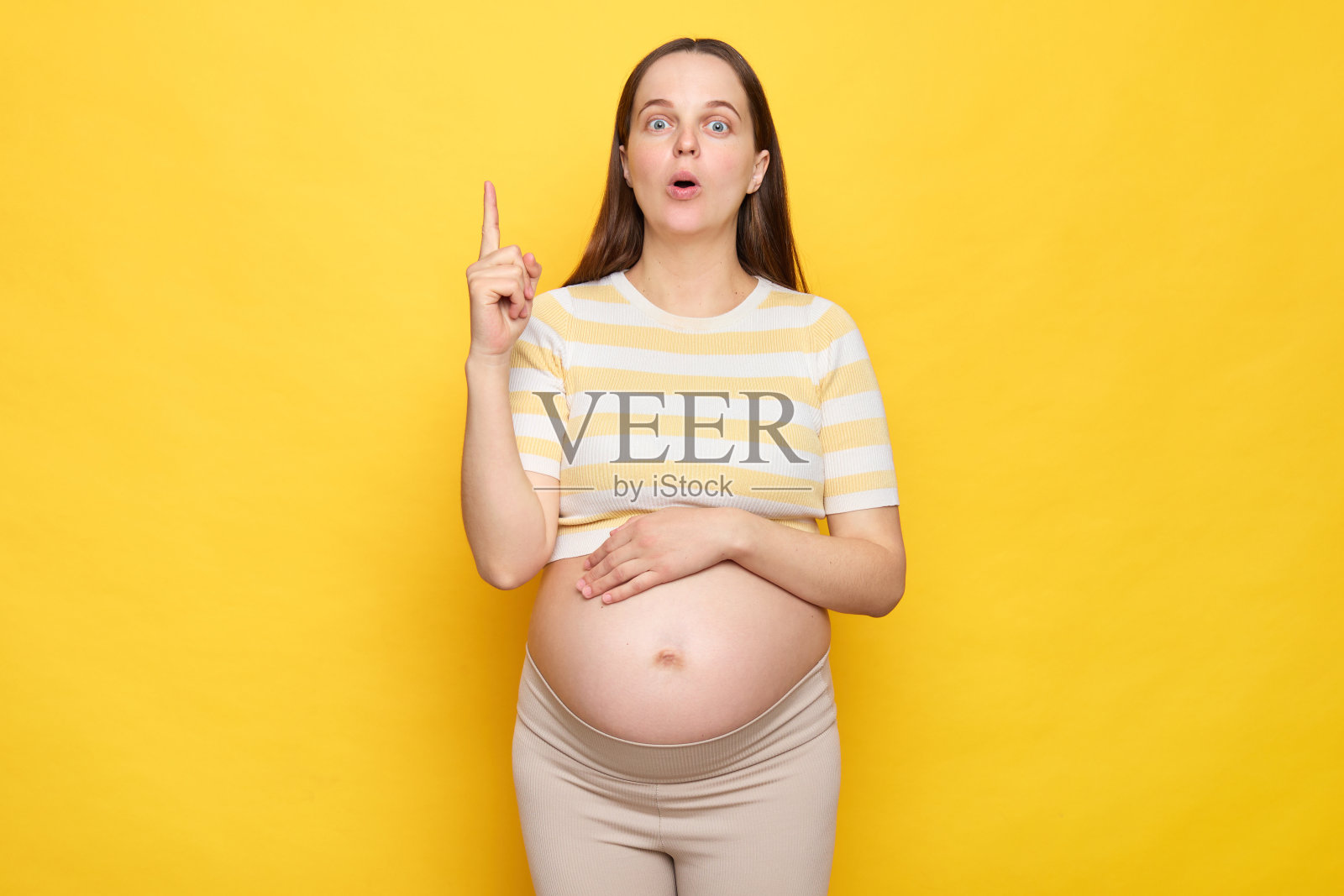 灵感兴奋的白人孕妇，穿着休闲服，在黄色背景上摆出孤立的姿势，有一个绝妙的主意，抬起手指，脸上露出惊讶的表情照片摄影图片