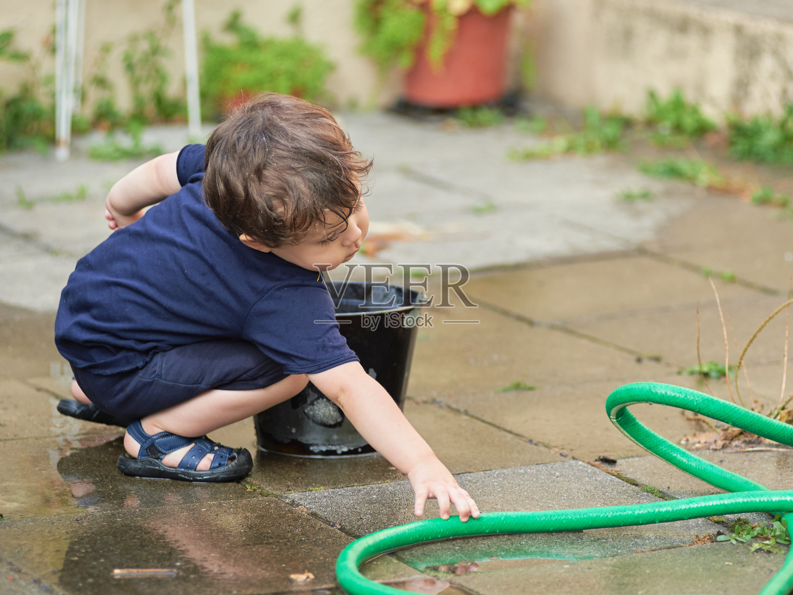 可爱的小孩在后院玩水照片摄影图片