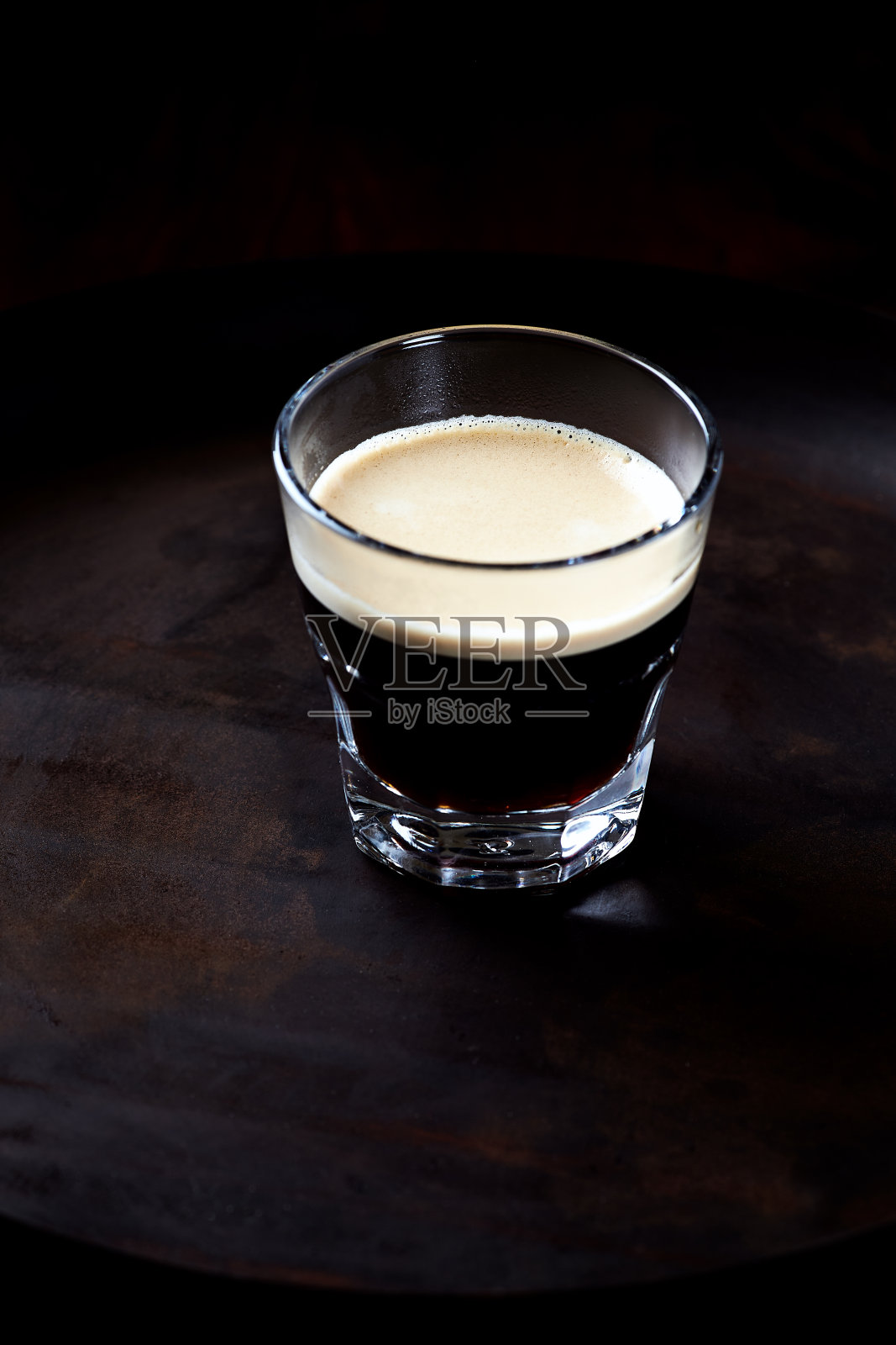 玻璃杯里的咖啡，背景暗。关闭了。照片摄影图片