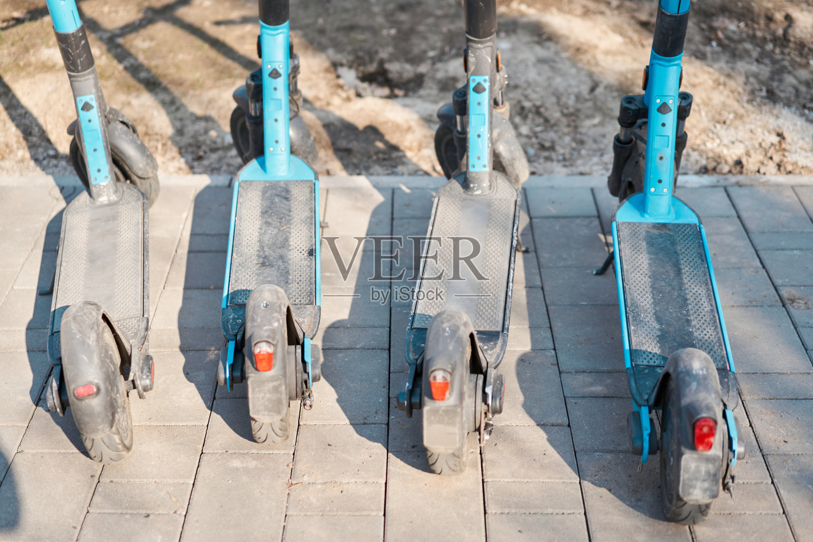 人行道上停着一排蓝色的电动滑板车照片摄影图片