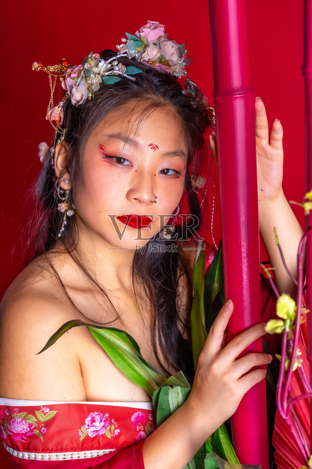 一个女人穿着红色的裙子，戴着花头饰，涂着红色的口红照片摄影图片