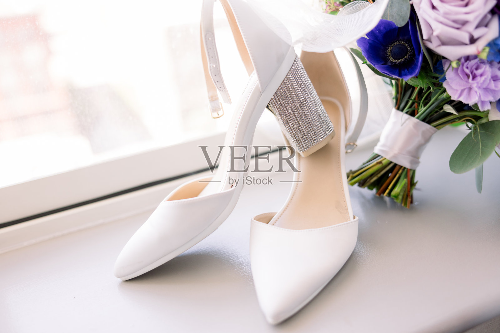 新娘花束旁边的窗台上有一双白色的婚礼鞋。照片摄影图片
