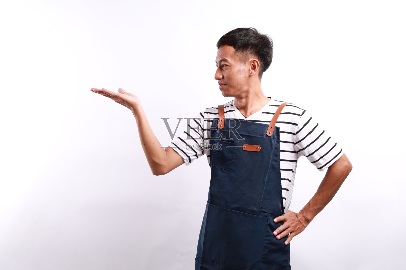 小企业主，系着围裙的亚洲人，手里拿着准备上菜的东西，站在餐厅的白墙上照片摄影图片