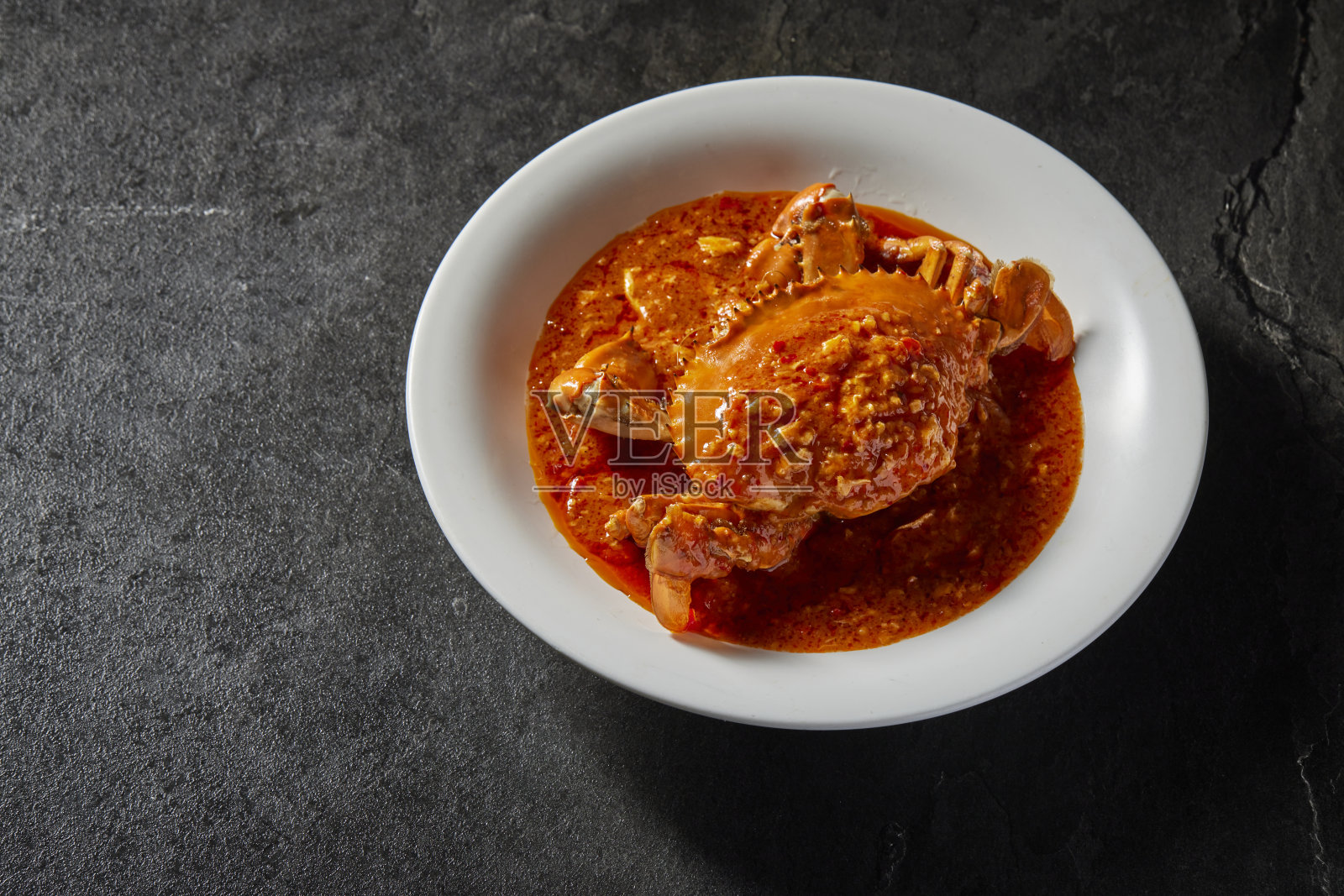 传统中式炒锅炒海鲜新鲜大肉蟹配辣椒辣咸蛋黄奶酪奶油酱盘在暗石桌亚洲咖啡厅酒店豪华清真食品餐厅宴会菜单照片摄影图片