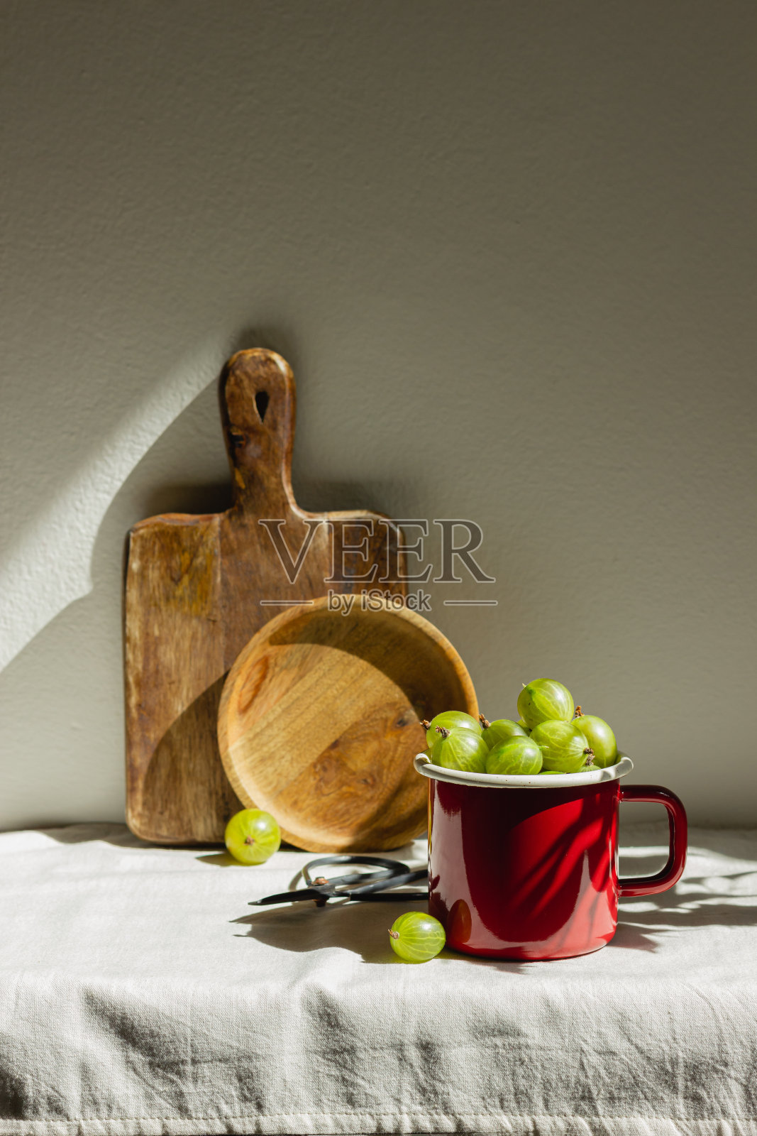 阳光下红色珐琅杯里的醋栗照片摄影图片