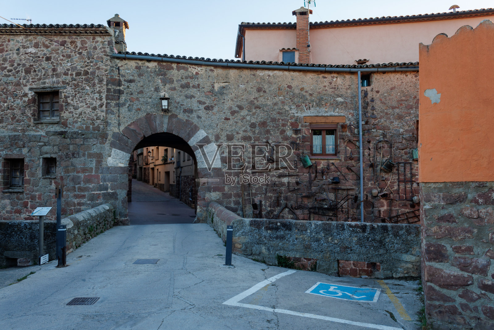 通往普拉德斯镇的入口拱门,正面挂着农具照片摄影图片