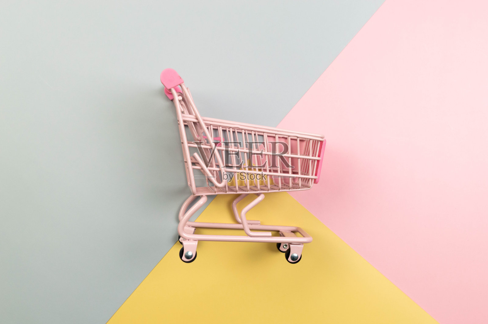 粉红色的购物车在彩色背景的顶视图。创意购物壁纸，销售。照片摄影图片