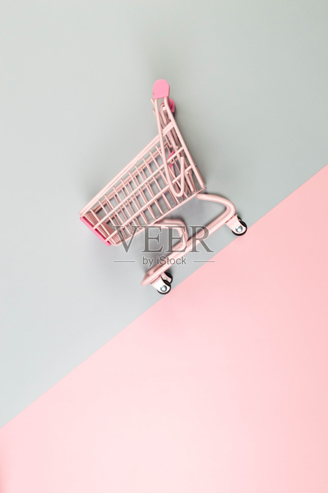 粉红色的购物车在彩色背景的顶视图。创意购物壁纸，销售。照片摄影图片