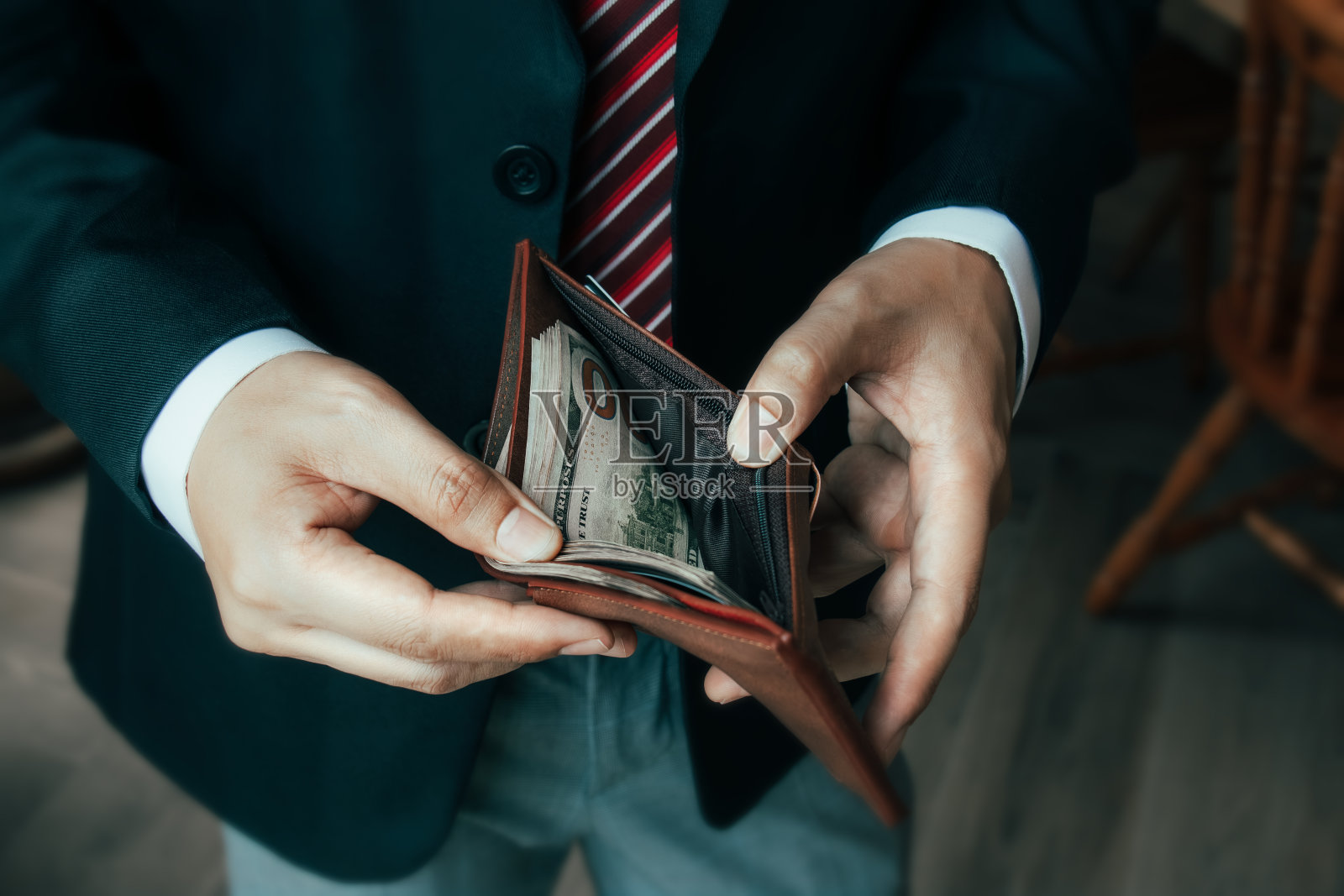 理财经济，节约金钱。商人拿出一张美元钞票，用它来付款照片摄影图片