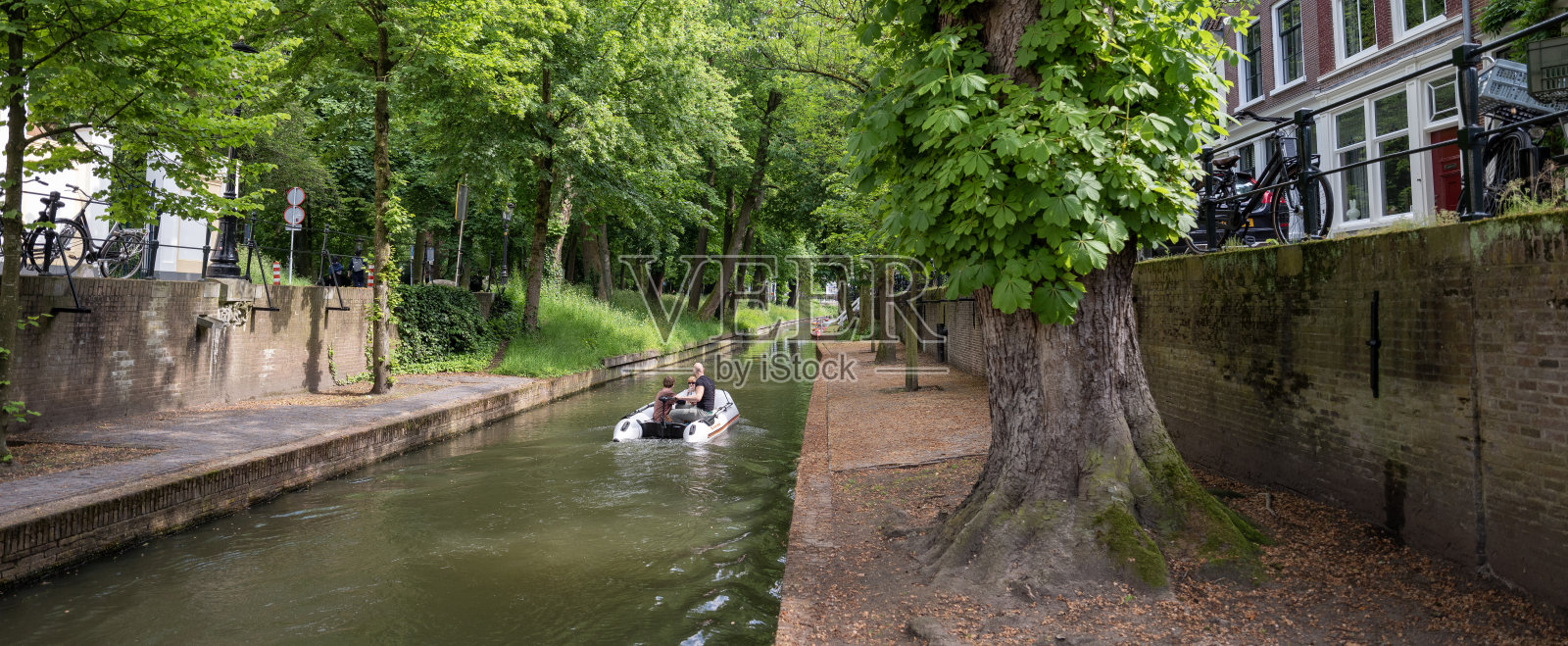 在乌得勒支老城的户外咖啡馆里，新wegracht水中的电动船和人们照片摄影图片