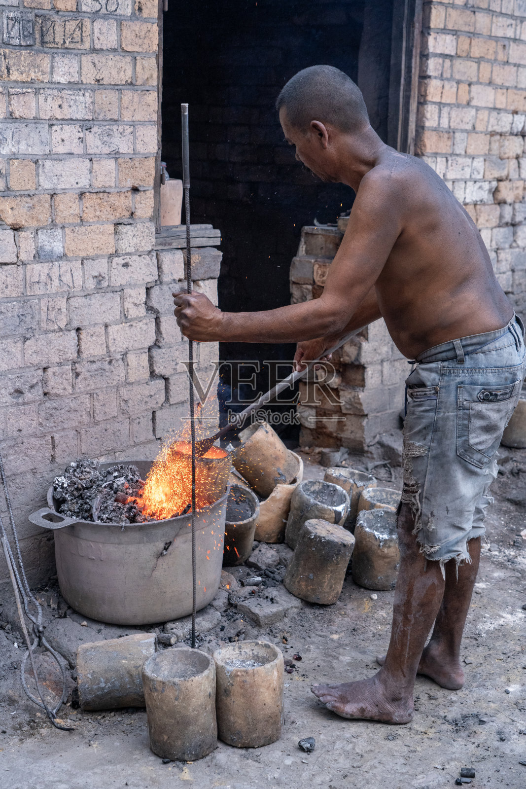 马达加斯加,当地工人在铝制锅的车间里照片摄影图片