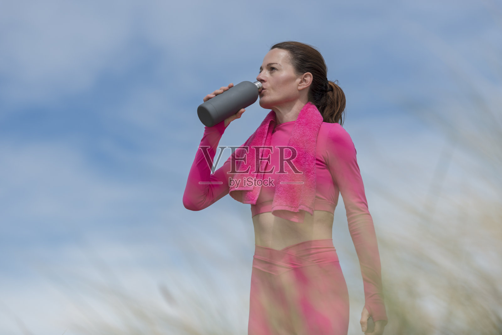 妇女在锻炼后喝水照片摄影图片