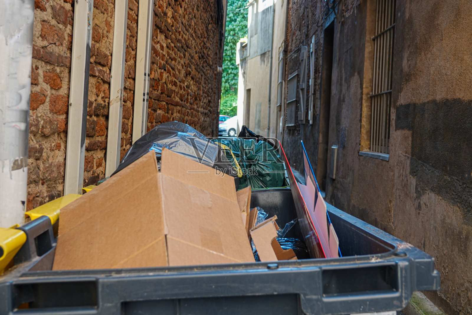 狭窄街道上的垃圾桶照片摄影图片