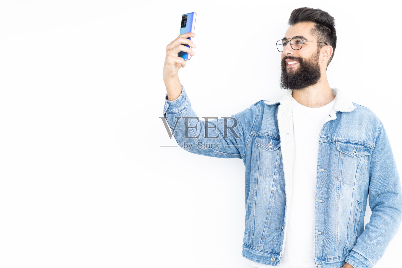 一名身穿牛仔夹克和白色t恤的男子一边自拍一边自拍照片摄影图片