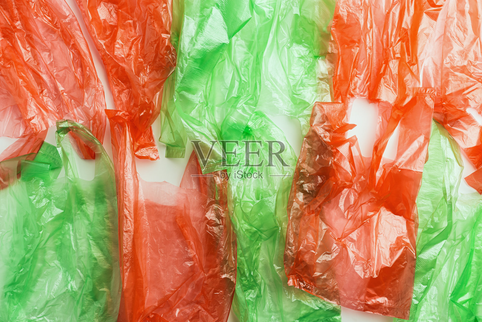 塑料袋纹理，俯视图皱褶塑料袋皱褶，红色和绿色纹理背景。表面为一次性聚乙烯包装。可重复使用的材料，包装废弃物照片摄影图片