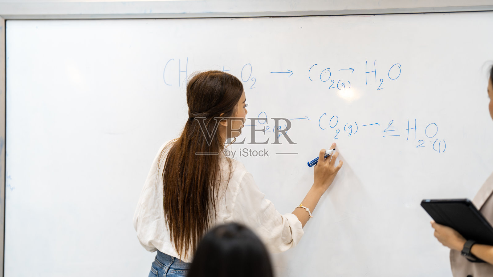 一个女人正在用记号笔在白板上写字照片摄影图片