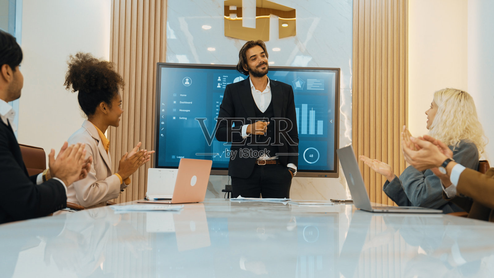 在装饰华丽的办公室里，各种各样的上班族和员工在鼓掌。照片摄影图片