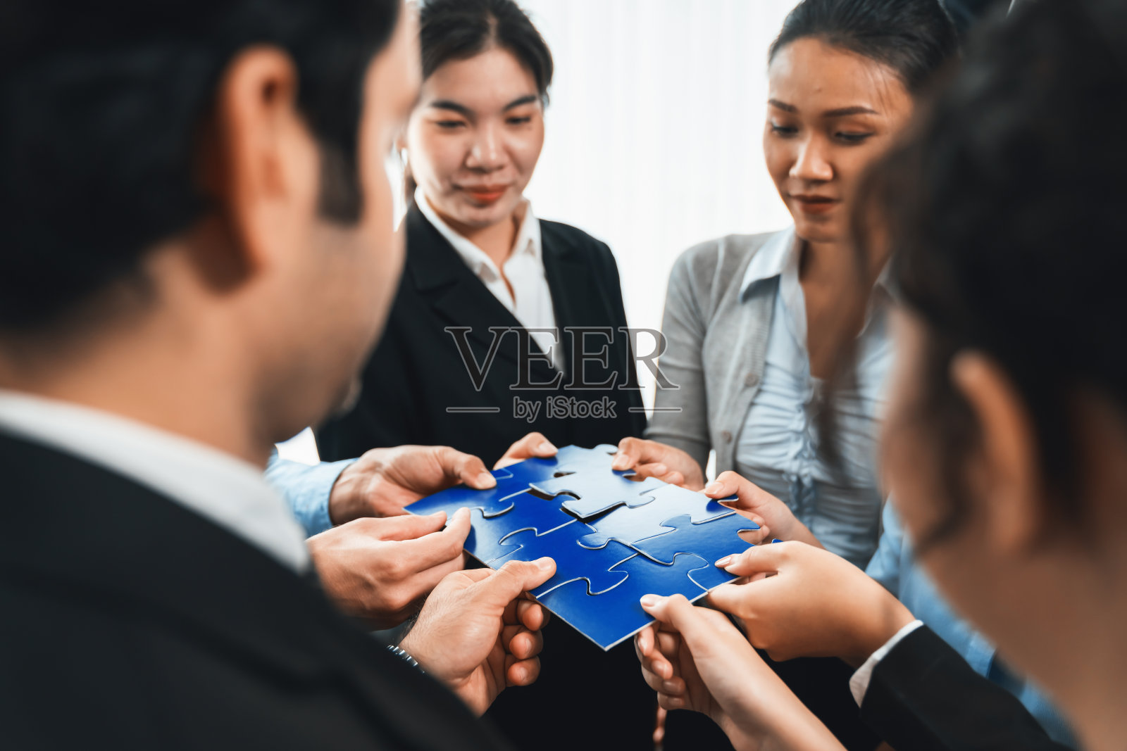 多民族商人将拼图拼凑在一起。服装照片摄影图片