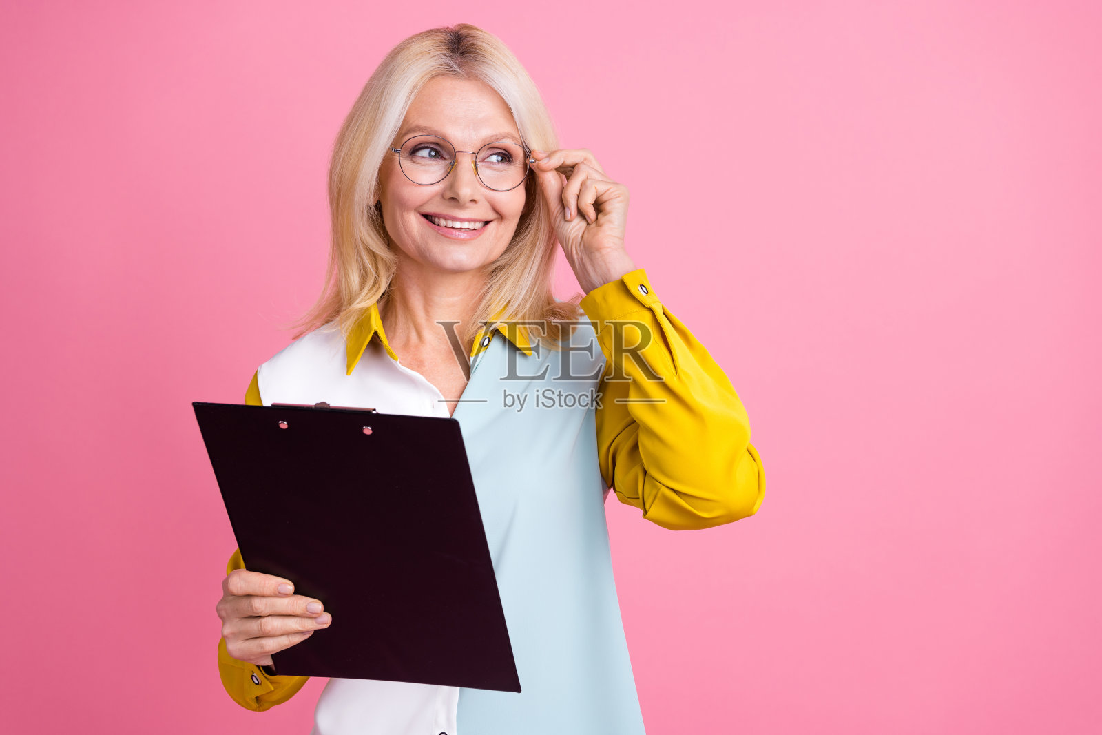 照片漂亮的老太太剪贴板看起来空的空间穿衬衫孤立在粉红色的背景照片摄影图片
