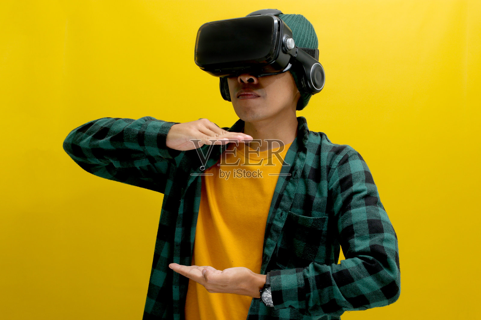 亚洲男子戴着VR头显与虚拟现实中的虚拟物体互动照片摄影图片