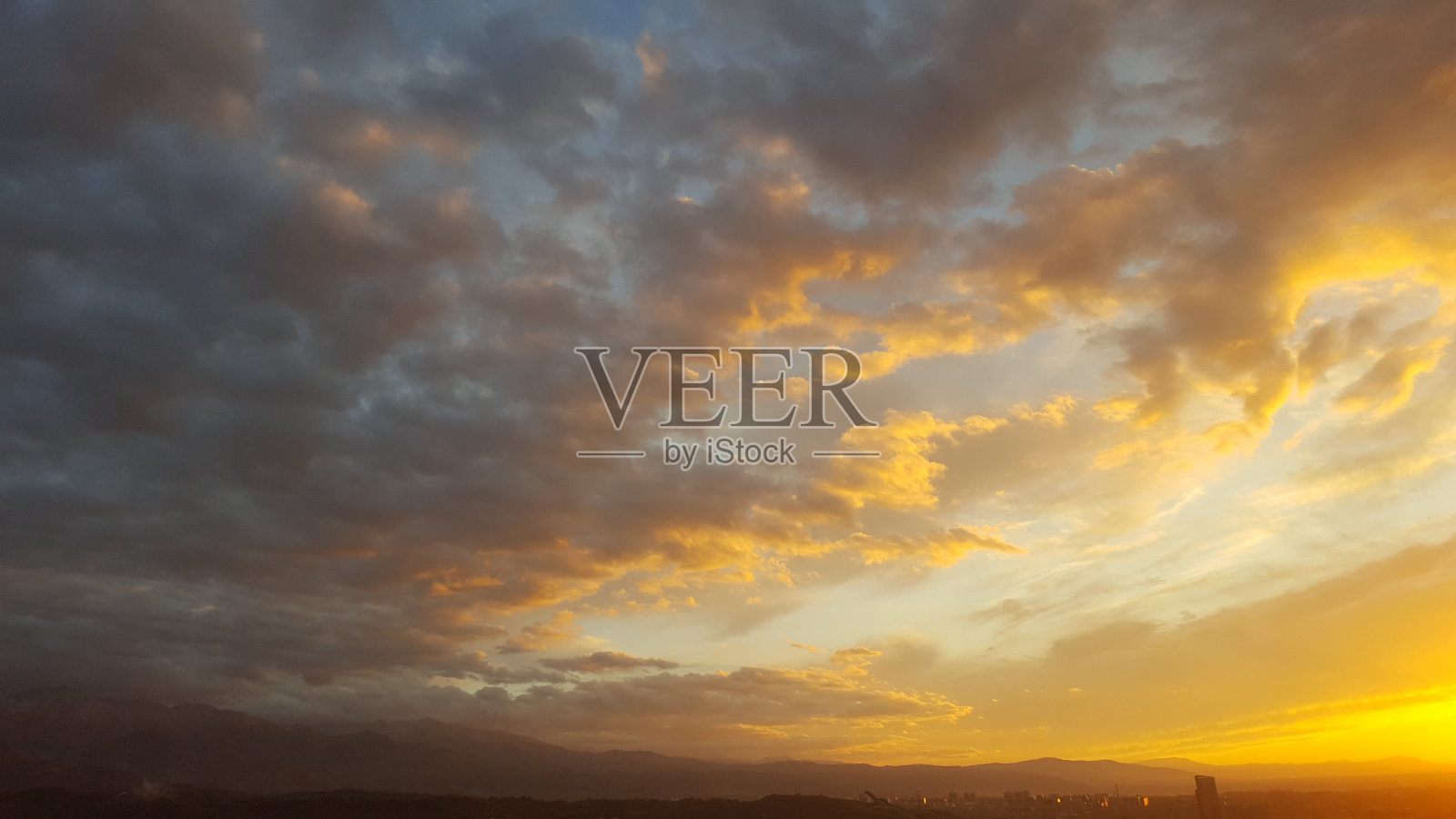 随着黄昏的降临，地平线上闪烁着丰富的琥珀色和深红色的色调，与广阔的云层混合在一起，塑造了一个迷人的全景，留下了耀眼的余辉照片摄影图片