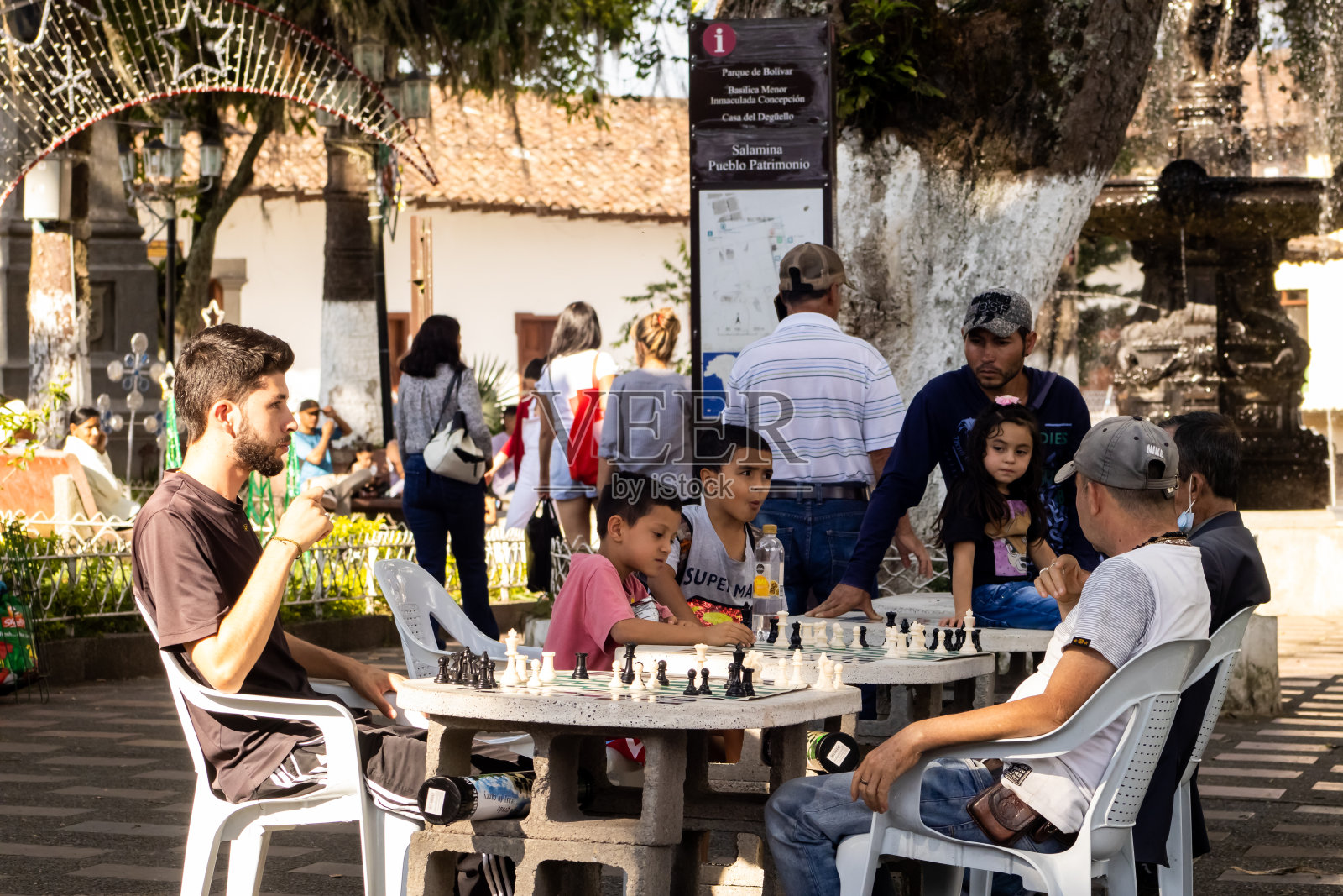 位于哥伦比亚卡尔达斯省的萨拉米纳古城中心广场上，人们正在下棋。照片摄影图片
