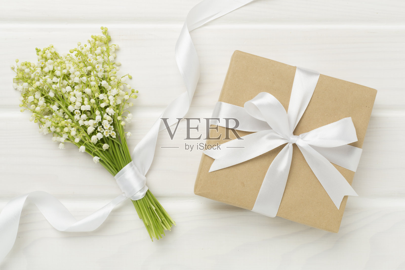 山谷的百合花与礼盒木制背景，俯视图照片摄影图片