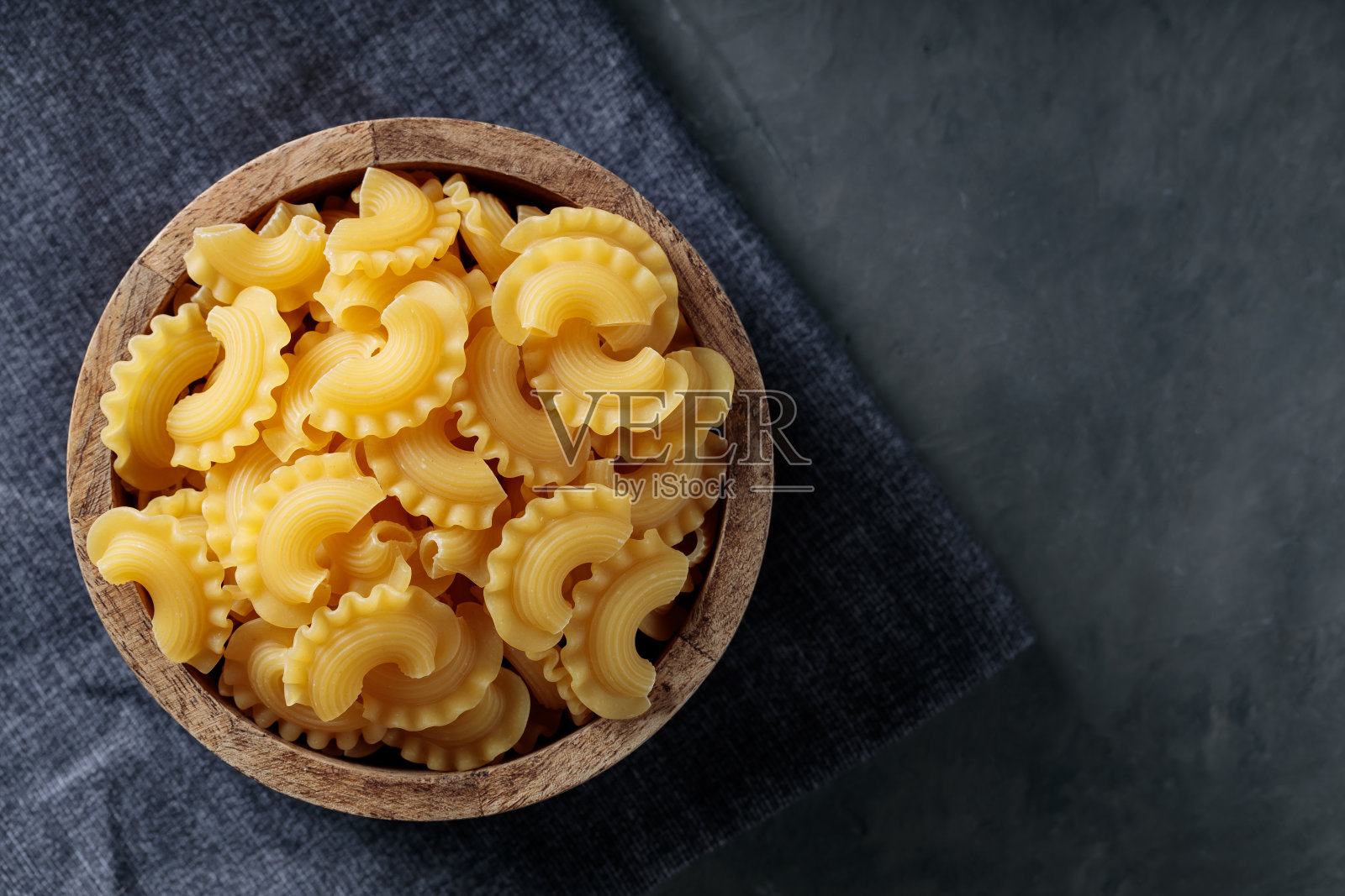 未煮熟的公鸡鸡冠意大利面在黑暗的混凝土背景，复制空间照片摄影图片