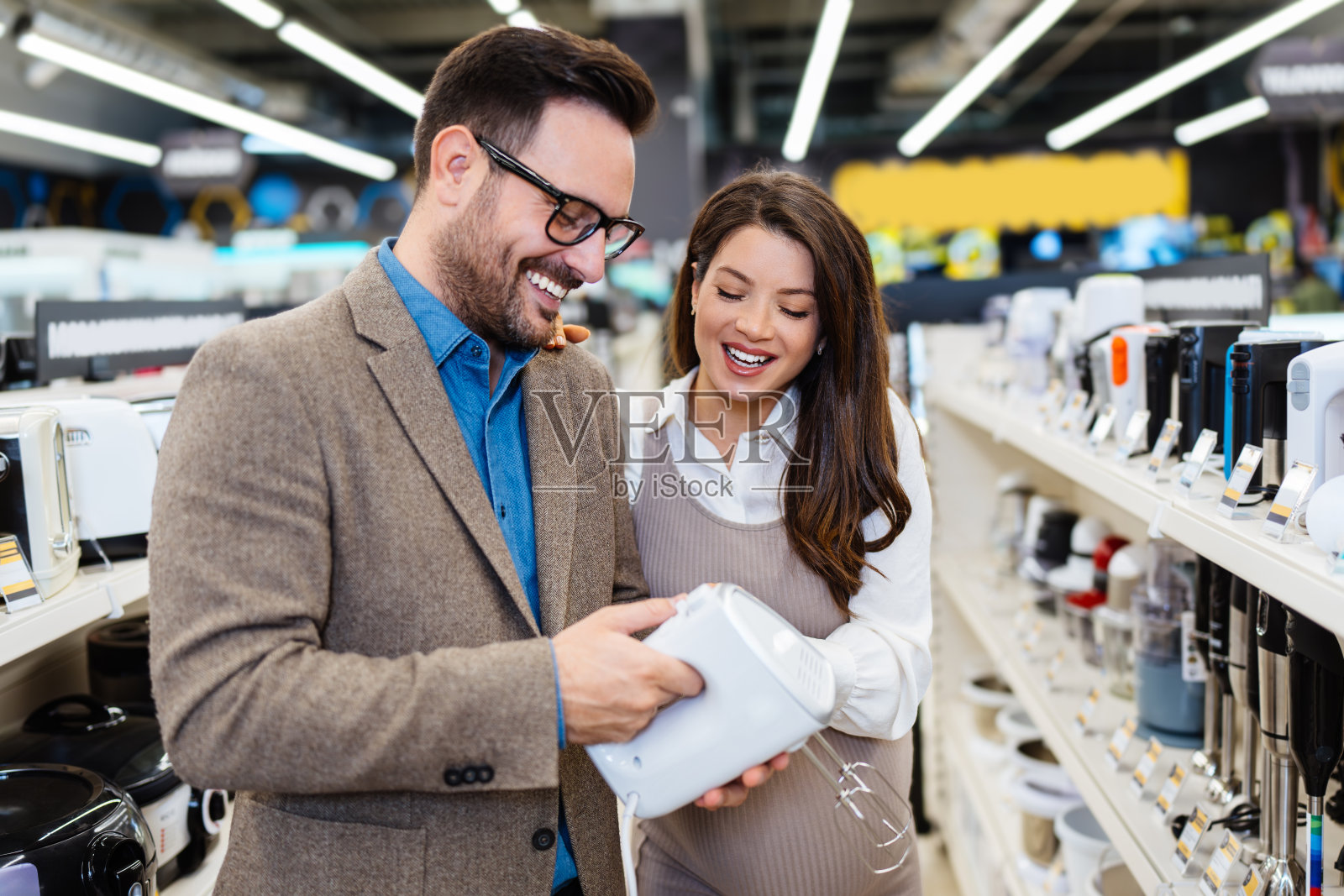 年轻夫妇在现代科技商店买东西。照片摄影图片