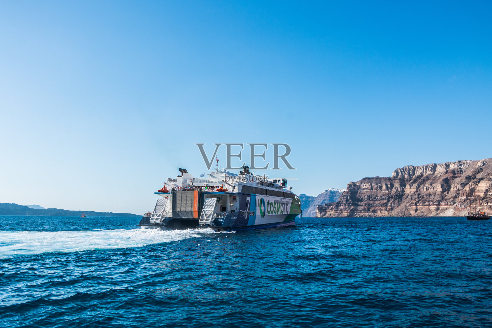 希腊圣托里尼岛海岸附近的旅游渡轮照片摄影图片