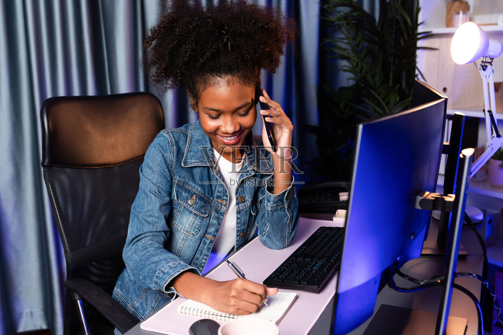 年轻的非洲创造者打电话给智能手机，看着屏幕显示器。热门人物。照片摄影图片