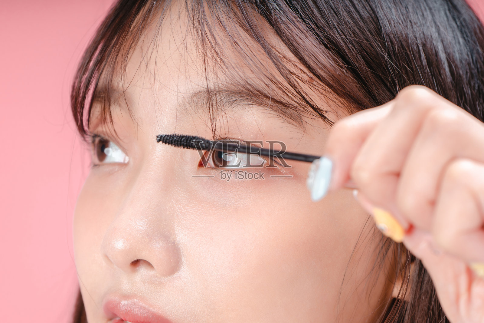 一位亚洲妇女在睫毛上涂睫毛膏照片摄影图片