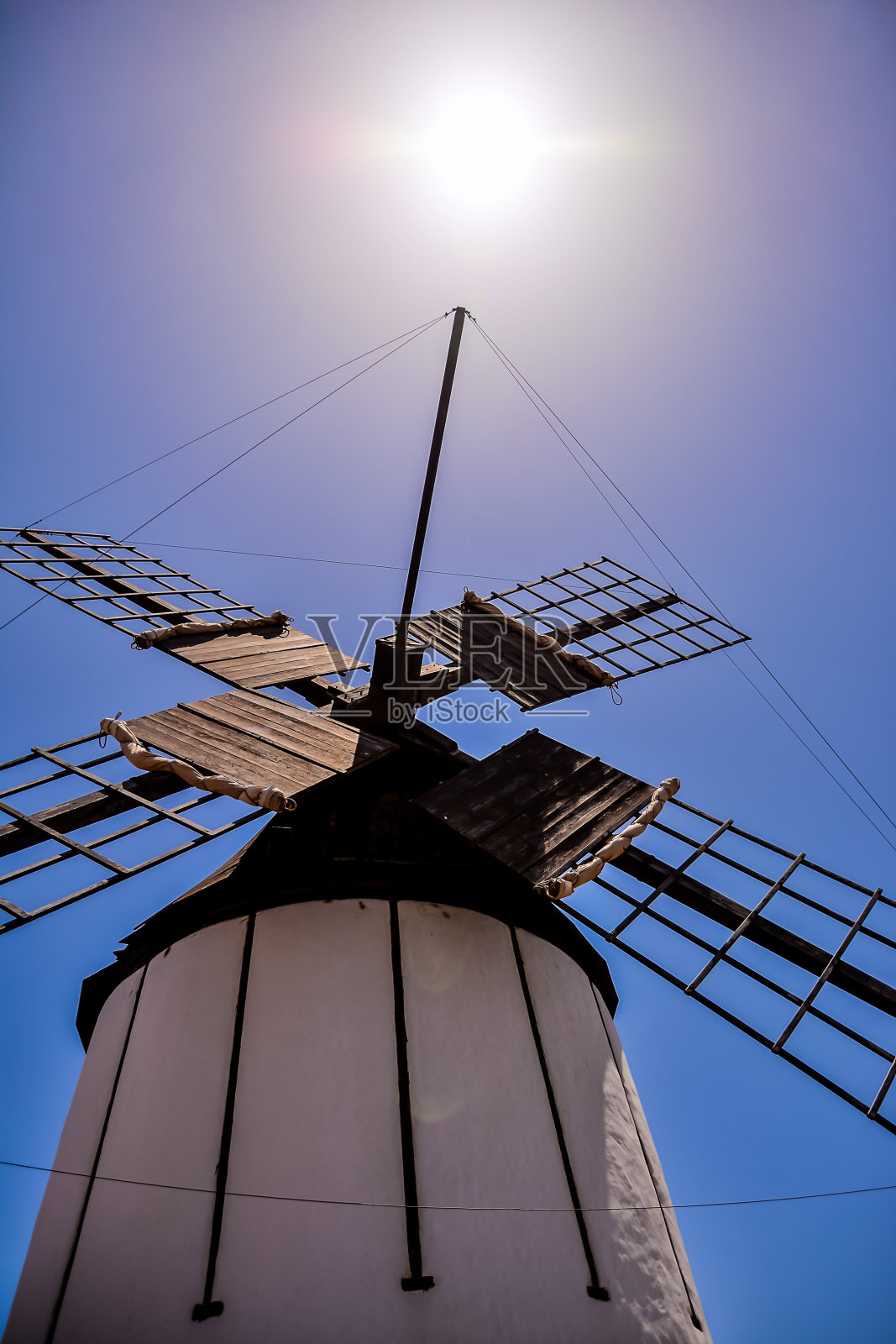 一座风车高高地矗立在天空中，阳光照耀着它照片摄影图片