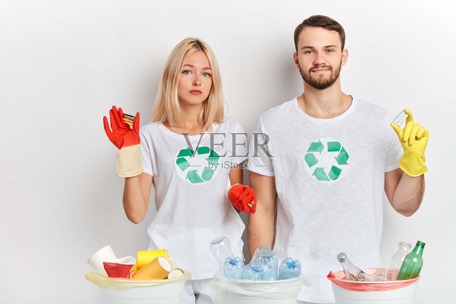 年轻貌美的一男一女在收集废旧电池照片摄影图片