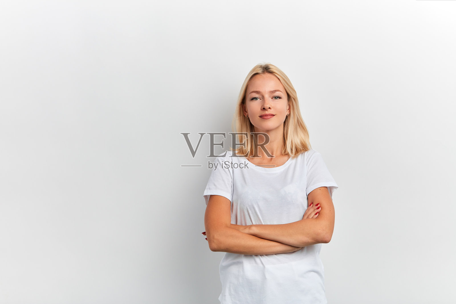 一个面带微笑，双臂交叉看着镜头的女人照片摄影图片