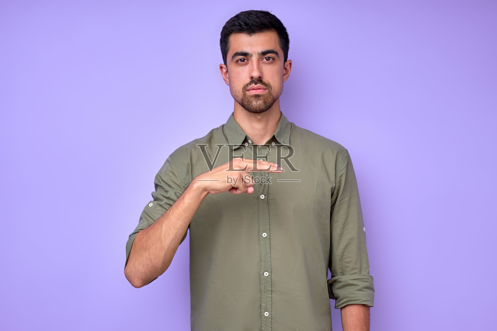 严肃英俊的男人用手指露出字母Hh。照片摄影图片