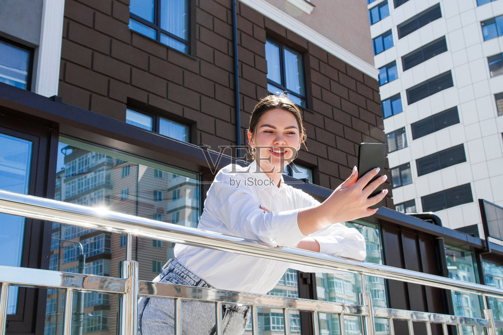 一位女商人在一个商业中心的背景下进行视频通话照片摄影图片