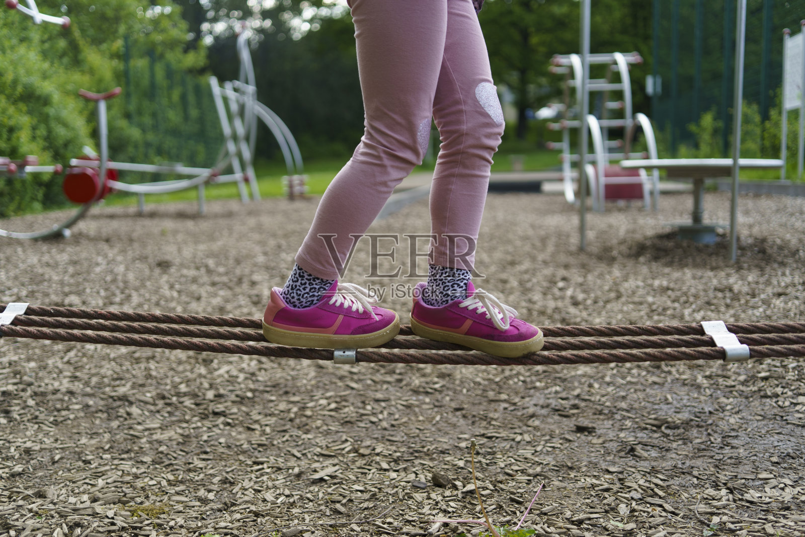 夏天，孩子们的腿在儿童运动场上沿着绳子走照片摄影图片