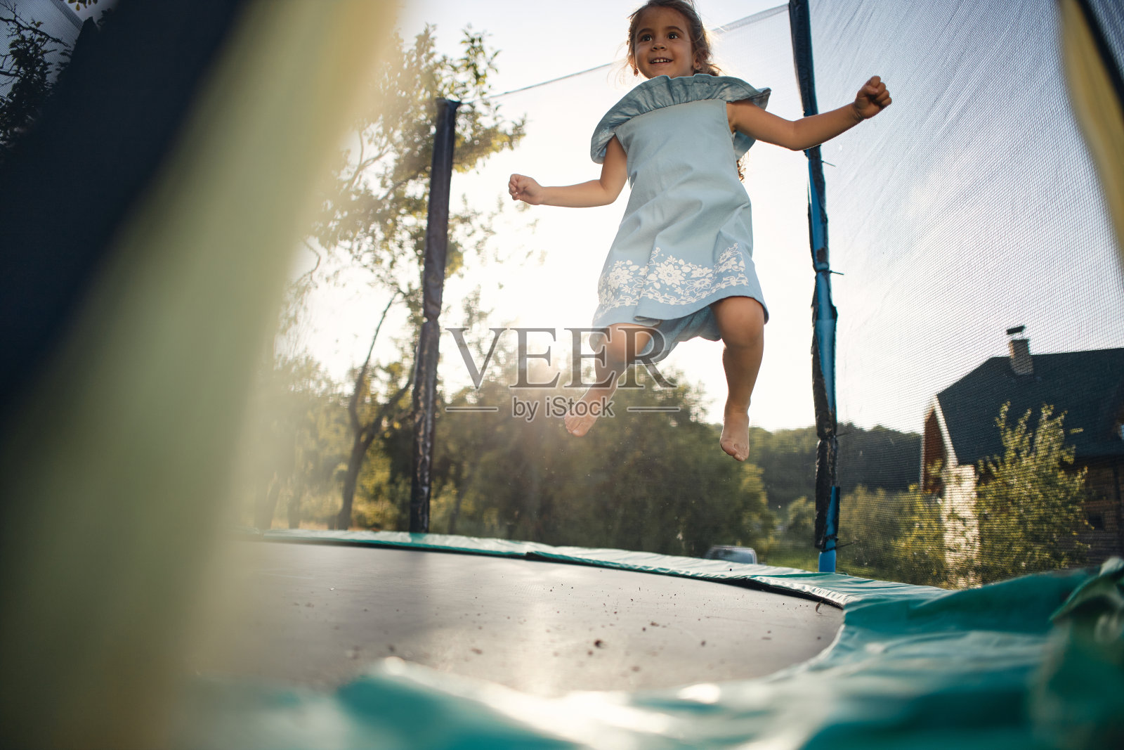 美丽的女孩在蹦床上享受夏天照片摄影图片