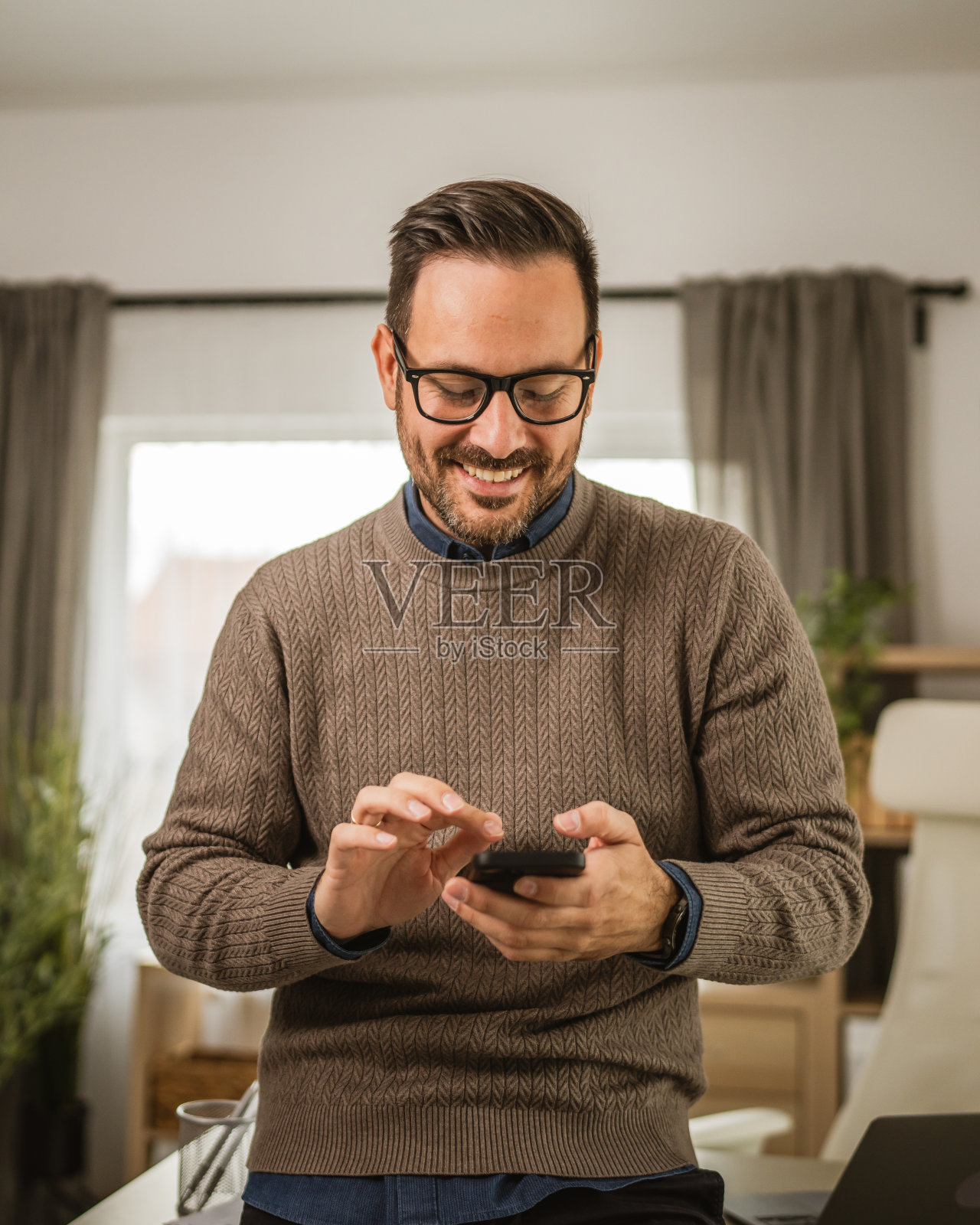 成年男子在办公室休息，用手机发信息照片摄影图片