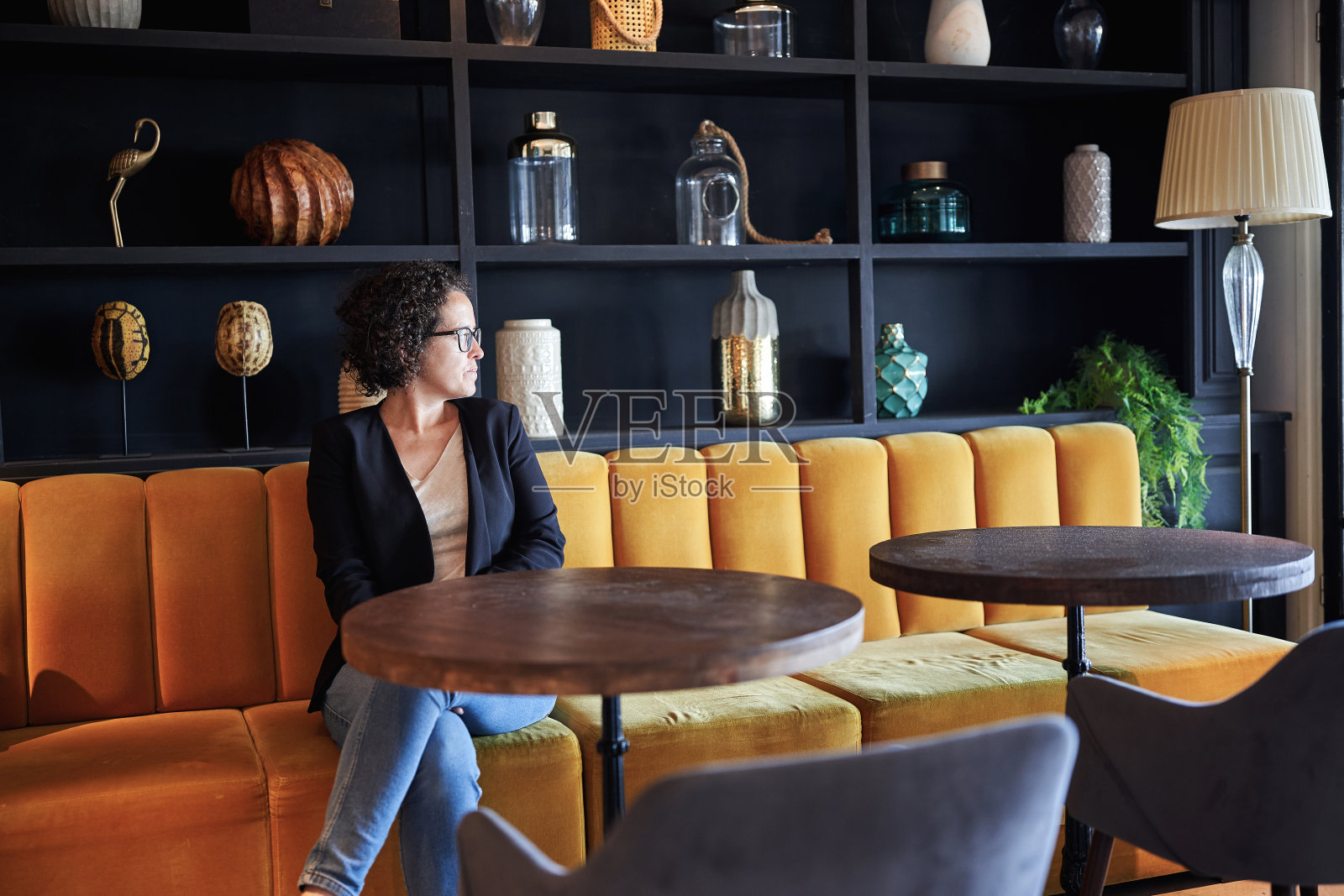 一位女士坐在酒店放松的大厅里。照片摄影图片