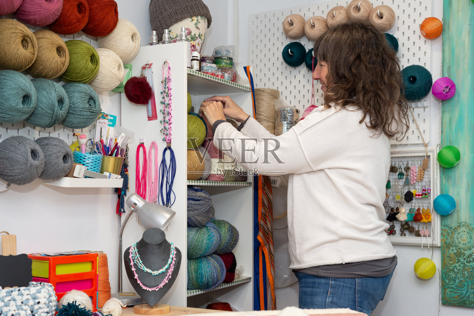 微笑的女人在她可爱的服饰店里工作。照片摄影图片