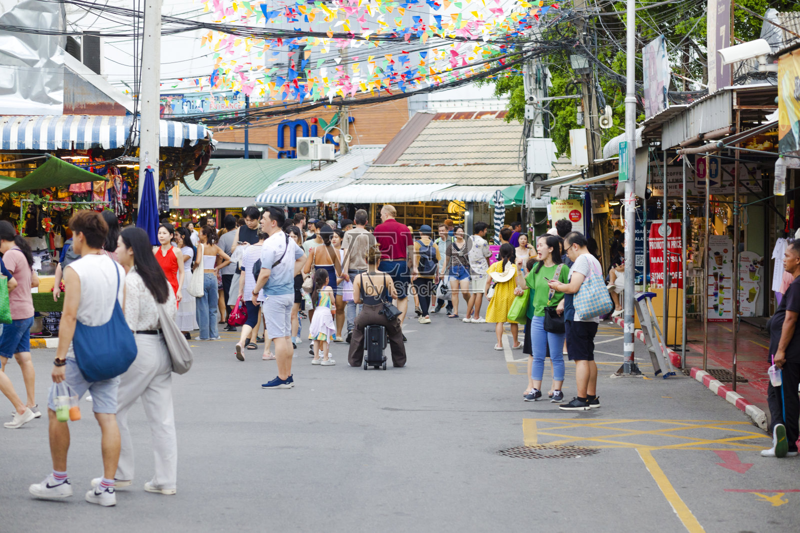 在JJ周末市场，中国女游客在可驾驶的行李上照片摄影图片
