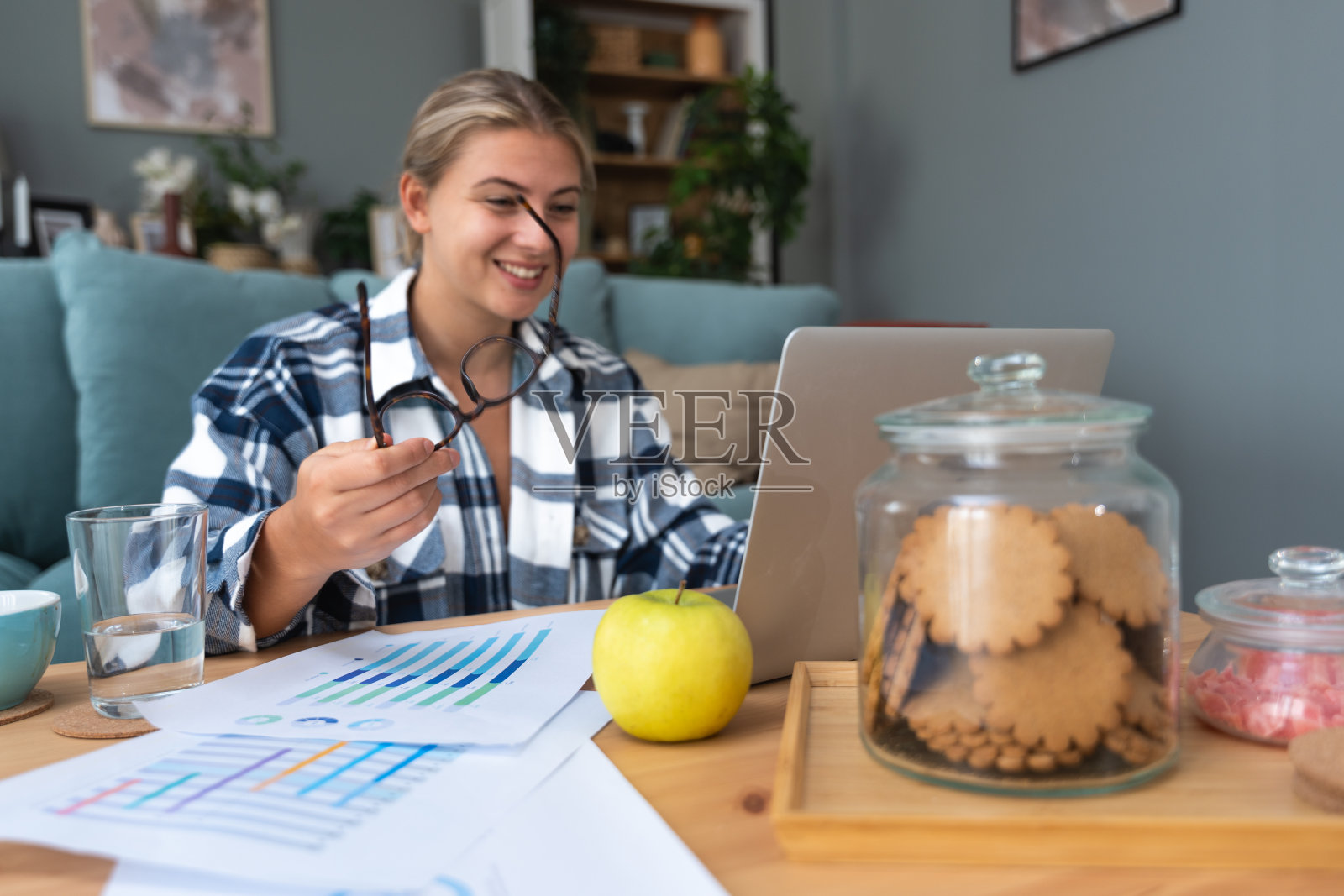 自我提升。年轻满意的学生或商业女性，在家里用笔记本电脑工作，从书本上学习，实施商业创新或为教育考试而学习。照片摄影图片