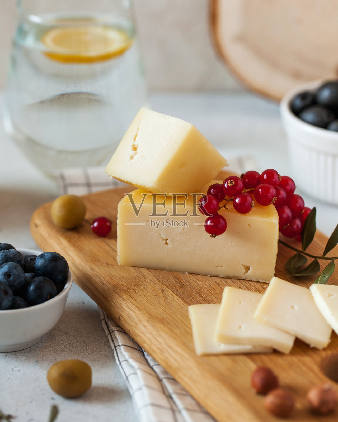 把意大利干酪堆在木板上，用橄榄、蓝莓和红醋栗装饰照片摄影图片