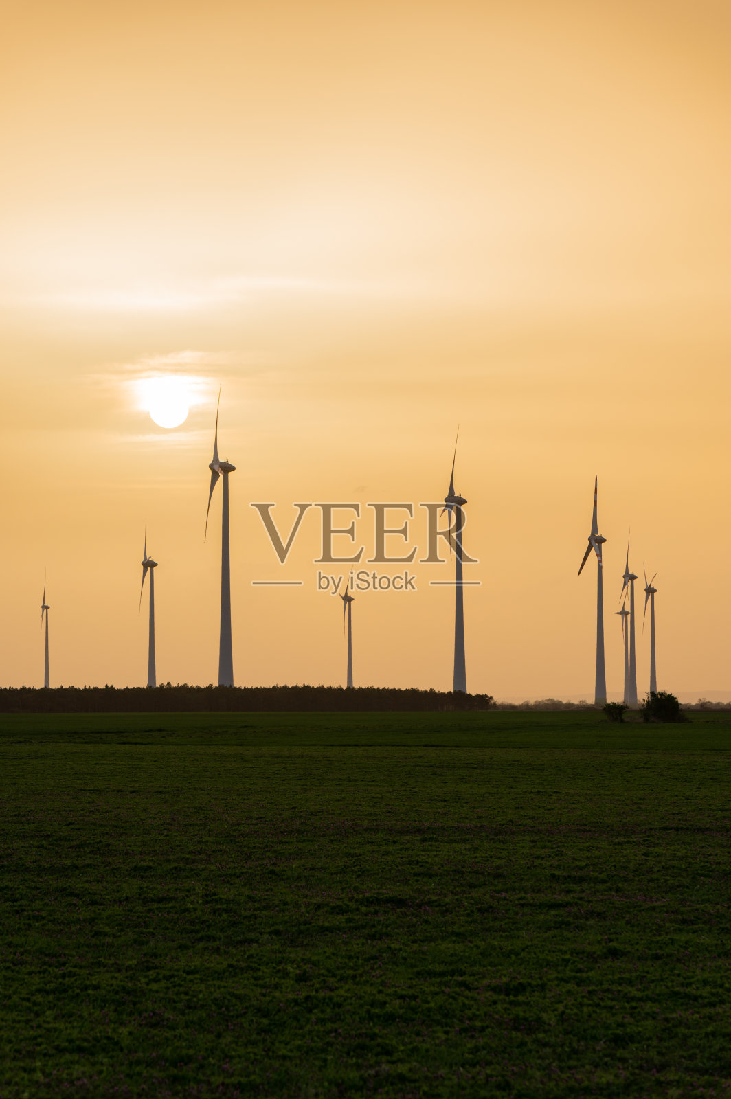 日落时农田里的风力涡轮机照片摄影图片