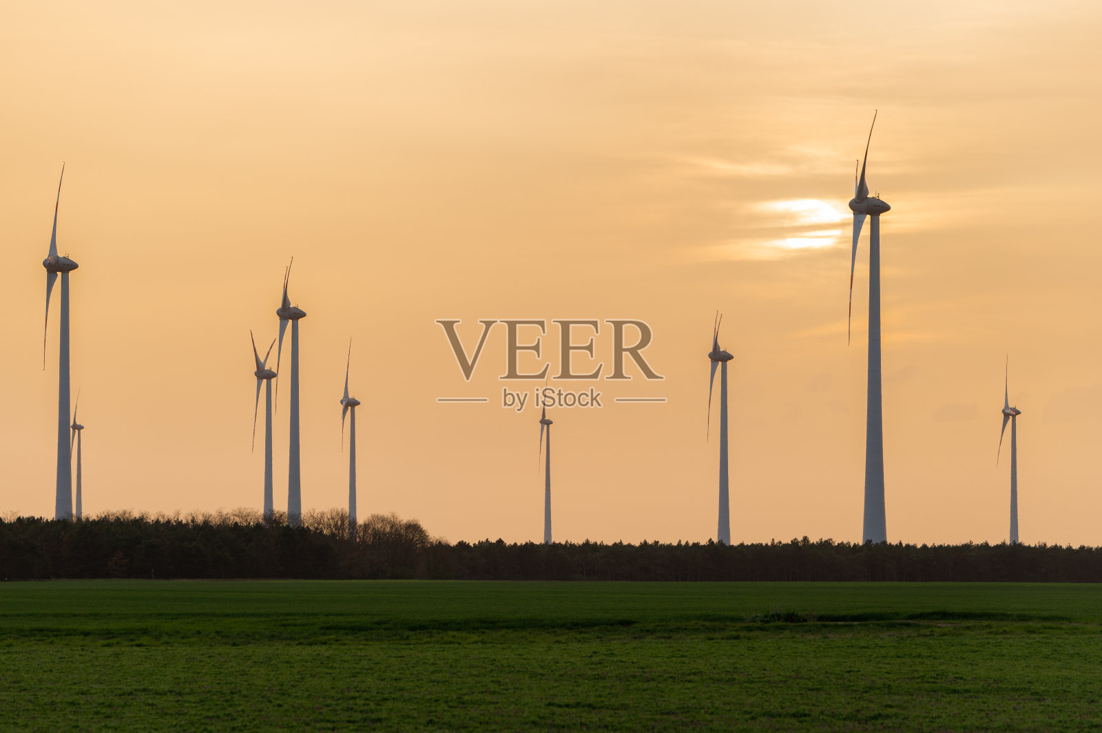 日落时农田里的风力涡轮机照片摄影图片